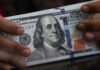 Dollar holds gains in thin trading as markets await Fed minutes, US GDP