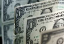 Dollar holds losses as risk appetite flickers ahead of central bank meetings